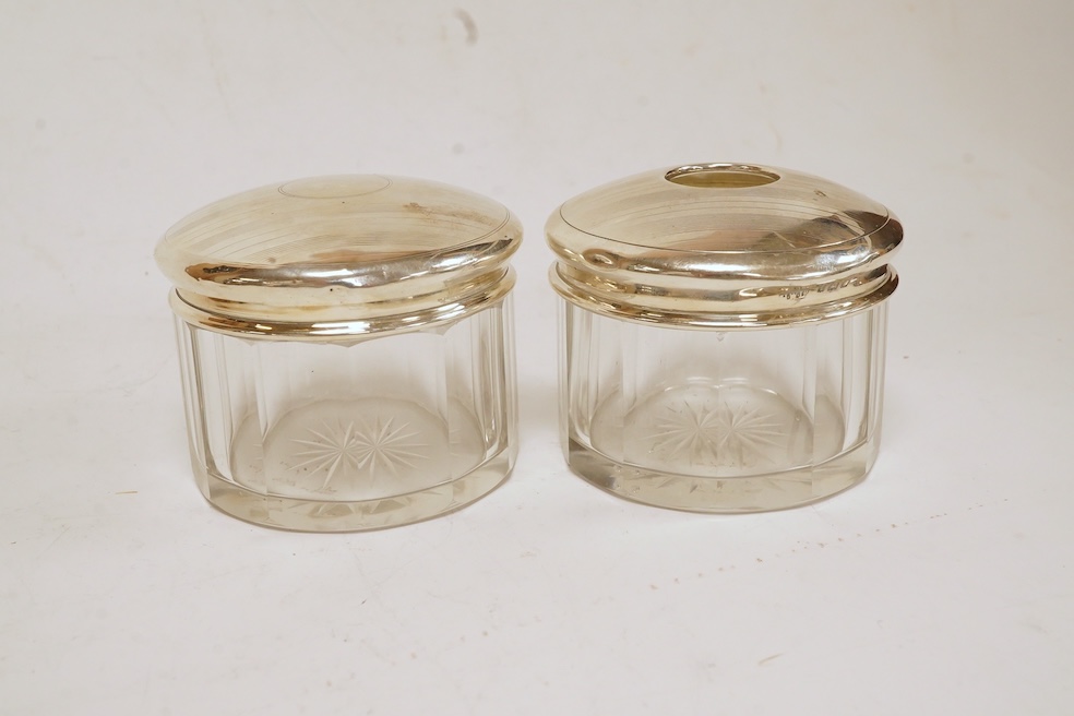 Six assorted silver lidded glass toilet jars including long rectangular, Birmingham, 1904, 22.9cm, together with a silver mounted hand mirror. Condition - poor